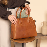 Styled Fit Perspective of Marsala Full-Grain Leather Handbag 여성용 on Model - Natural Daylight Drape