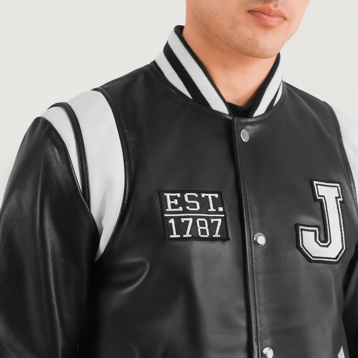 Close-Up Detail of Varsity &amp; Snap Button Hardware on Liberte New Jersey 블랙 Leather Varsity 가죽 자켓 남성용